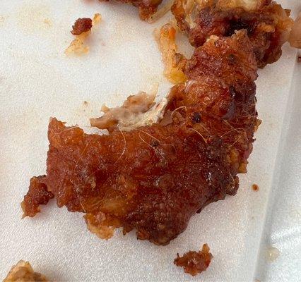 skin pulled off of a chicken wing to show the amount of hair