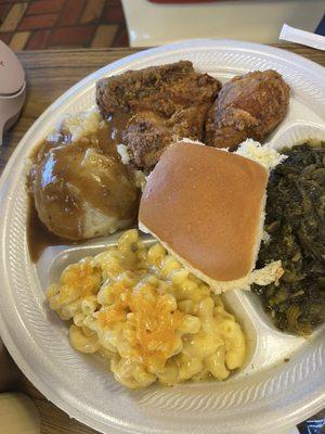 Mac and cheese, potatoes and brown gravy, fried chicken and greens with a roll