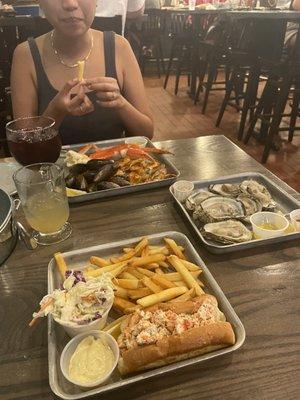 Lobster Roll Sandwich, crab legs, mussels, oysters, sangria cocktail, fries, shrimp