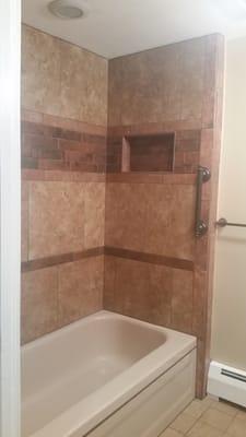 The grab bar and the left end of towel rack. This shows how the items match with the tub, wall paint and three types of tile.