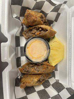 Philly Cheesesteak Egg Rolls with cheese sauce for dipping & our signature slice of pineapple on the side