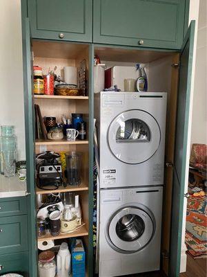 Hiding washer and dryer in the kitchen in emerald kitchen cabinets.