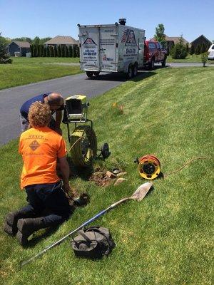 Using the camera to find any issues with a septic system's curtain drain. A jetter is also onsite to clean the drain if needed.