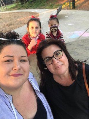 My kids photo bombing my cousin and I as we sat at one of the picnic benches watching the girls play