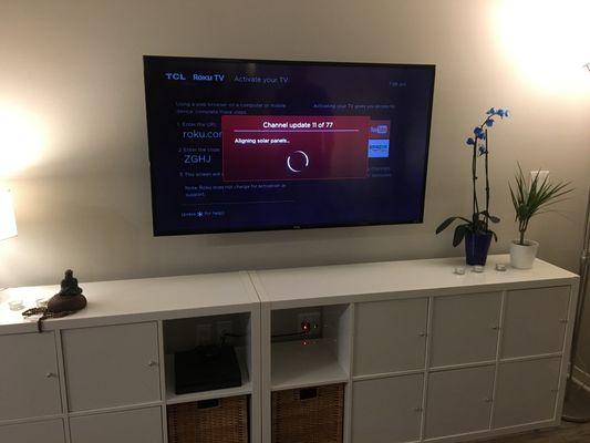 55" TV mounted in living room above media cabinet