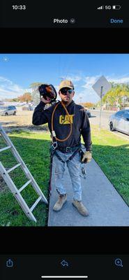 This is a picture of a worker, getting ready to climb trees for pruning