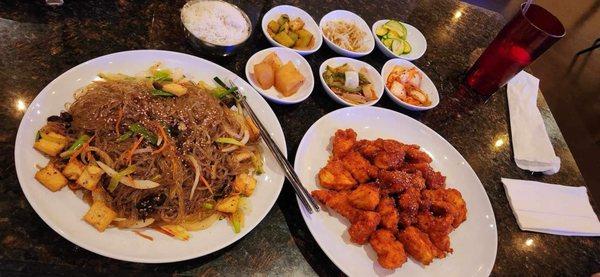 Glass noodle (sweet potato) with tofu (left)  and sweet spicy chicken (right) and 'sides) w rice in the back.