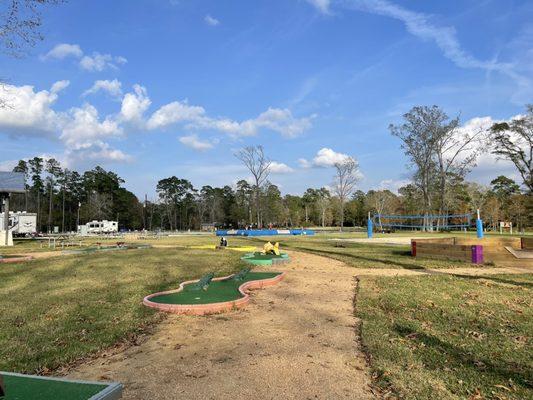 View of the volley ball net, mini golf, and jump pad