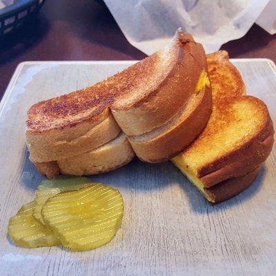 Grilled cheese sandwich with pickles on the side