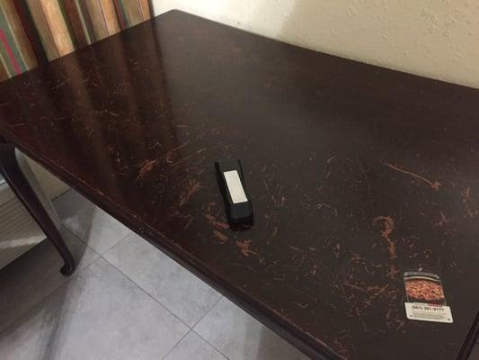 Dirty table and remote with batteries held in place with medical tape