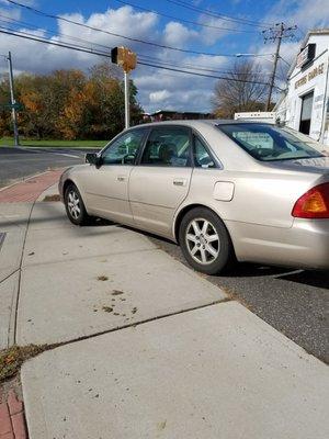 Again a car parked practically into the curb cut blocking the sidewalk. If someone used a wheelchair they would be stuck in the street.