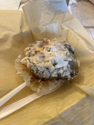 Lemon blueberry muffin with frosting and utensils.