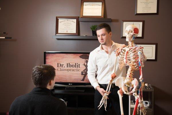 A chiropractor talking to a patient.