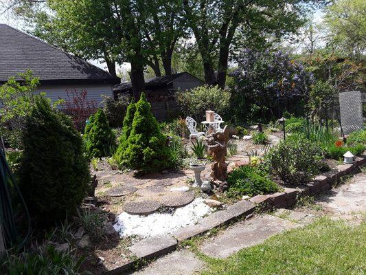 A backyard garden that was all weeds and trees transformed to a welcoming sitting place