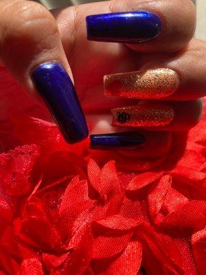 medium length with old English initial a red heart two glittered nails rest are blue with glitter shaped coffin