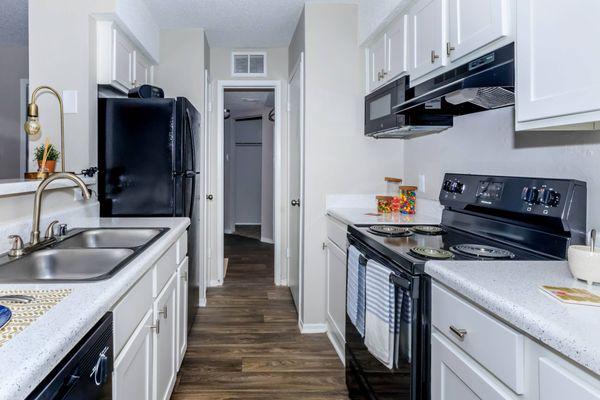 a kitchen with black appliances and white cabinets