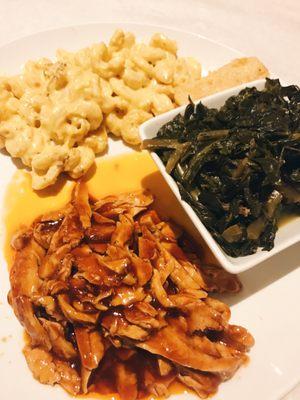 Vegan BBQ with sides of macaroni and collards. Also includes a slice of cornbread.