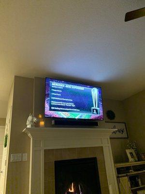 Mounted TV and sound bar with hidden cables behind it.