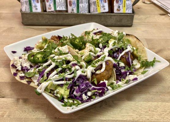 Vegan Tacos - Three cauliflower-based tacos topped with cabbage, sour cream and crumbling cheese. Vegan option available.