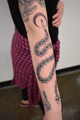 Geometric snake linework blackwork tattoo with dotwork moon