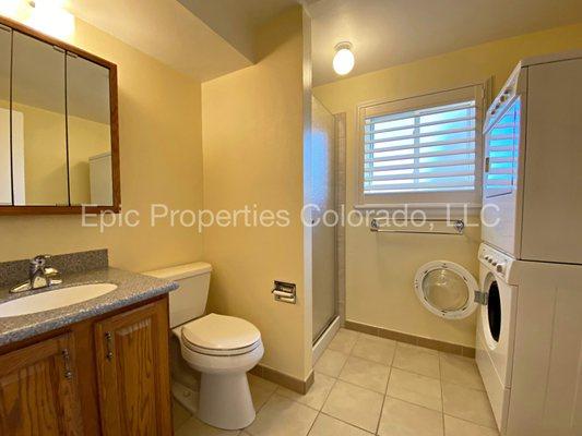 Spare bathroom with stackable laundry.