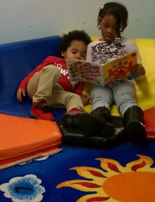 A 4 year old student reading to our 2 year old student! They can also learn from one another.