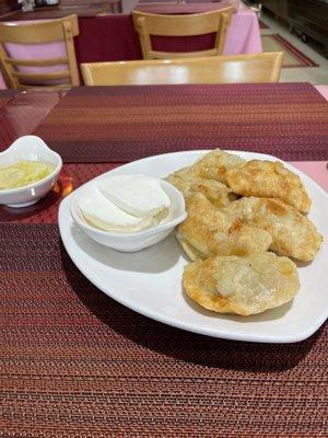 Mushroom and Sauerkraut Pierogis with sour cream  and sweet and sour complimentary pickle. Yum.