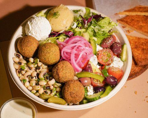 Authentic handmade falafel (ancient family recipe). Healthy beans, green salad, Greek salad, hummus, dips and feta. pickled onions.