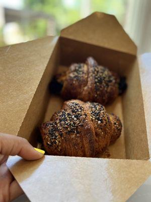 A pair of warmed up Broccolini and Three Cheese Croissants boxed to-go for a bike ride at the Big Creek Greenway.