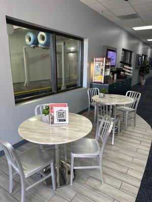 Tables, coffee, snacks, and a view to the wash area in the lounge