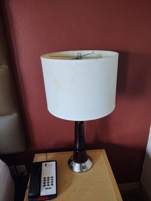 A lamp, a night stand and their stains.