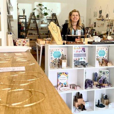 Owner Jennifer at her work table with hoop earrings and crystals