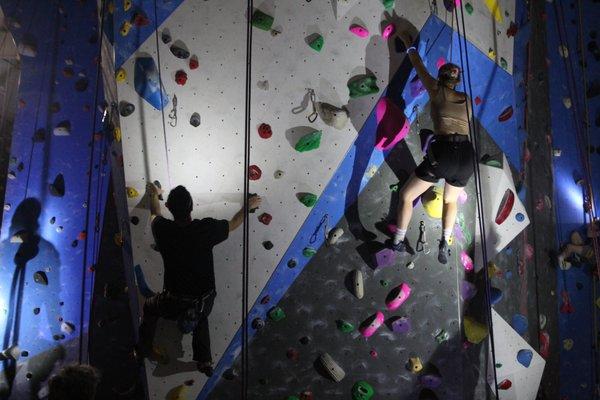 Members climbing top-rope with headlamps on during our Lights Out Event for Halloween.