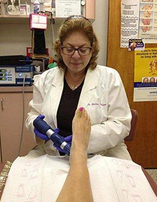 Podiatrist, Dr. Corinne Kauderer, DPM, FACFAOM treating a patient