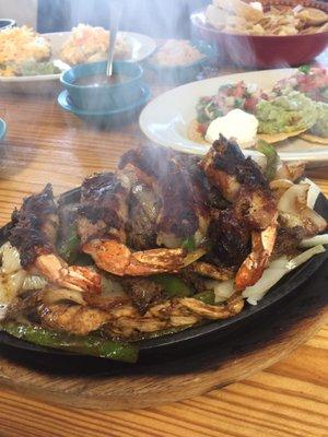 Bacon-wrapped shrimp fajitas for two with chicken & beef. Comes with guacamole, pico, sour cream, rice & beans.