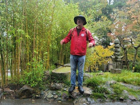 Tour guide eric speaking in front of a fountain and bamboo