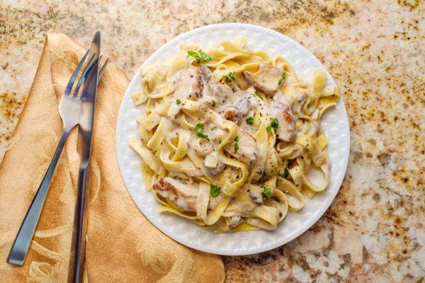 Creamy Homemade Alfredo Sauce over a Bed of Fettuccine Pasta. Too tasty!