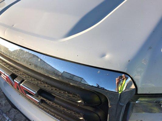 dent on hood of car from fence falling