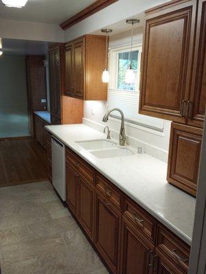 Another shot of the galley kitchen after completion.  New cabinets, quartz counters, sink and faucet, and tile floor.