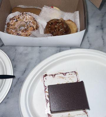 In the box: mini coffee eclair, mini cheesecake, sticky bun, paris brest. On plate - chocolate cake