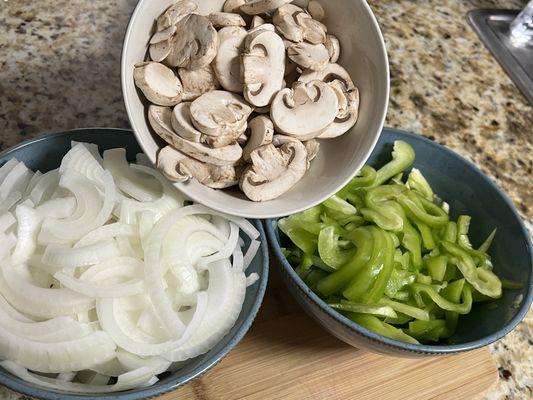 Fresh sliced onions peppers and mushrooms