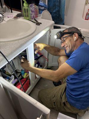 Javier repairing the bathroom sink clog.