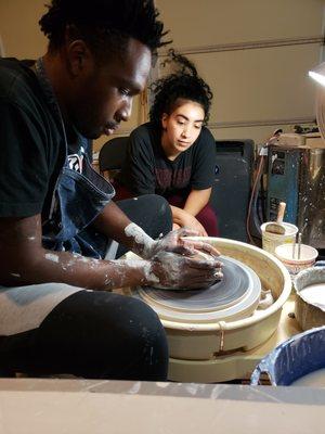 Students Learning How To "Throw" Pottery On The Wheel.