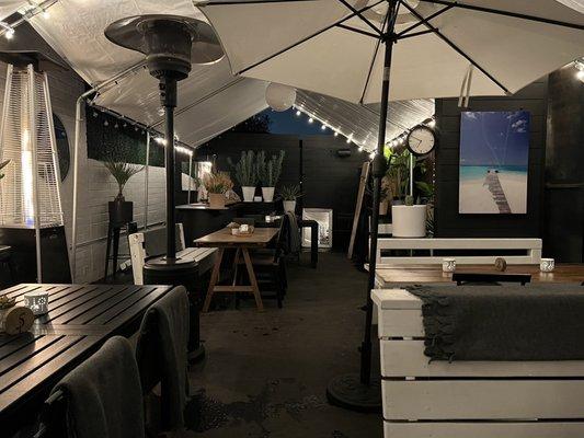 Outdoor patio with tents, umbrellas, and heaters. Very cozy!