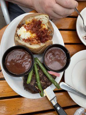 Petite filet mignon and baked potato with two sauces.