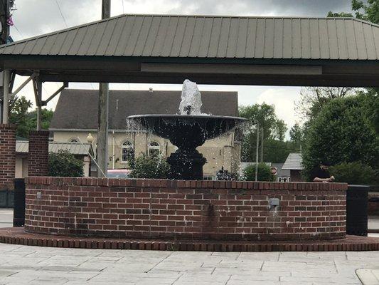 Parking lot. Outside Harmony House in the parking lot is a beautiful fountain w picnic tables.