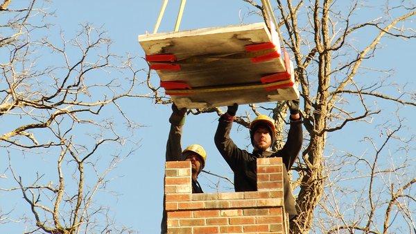 Working with the crane operator to safely remove a stone cap