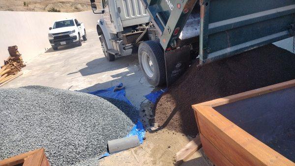 Multiple loads of gravel and dirt to build these custom plantar boxes!  They were built and filled, the garden patio came out great!