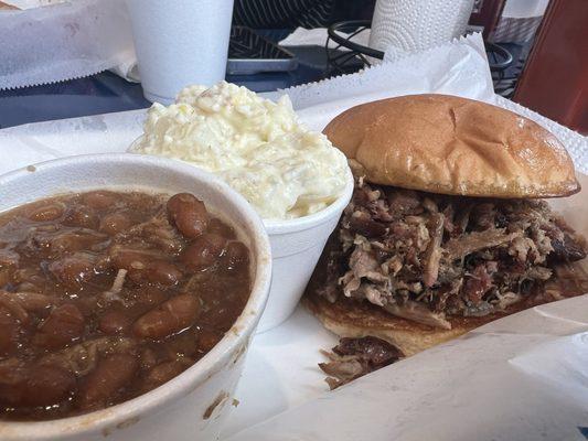 Pulled pork sandwich, baked beans, and potato salad