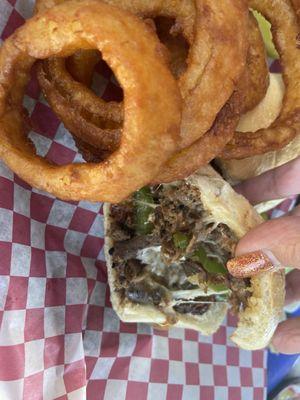 Philly steak sandwich and onion rings